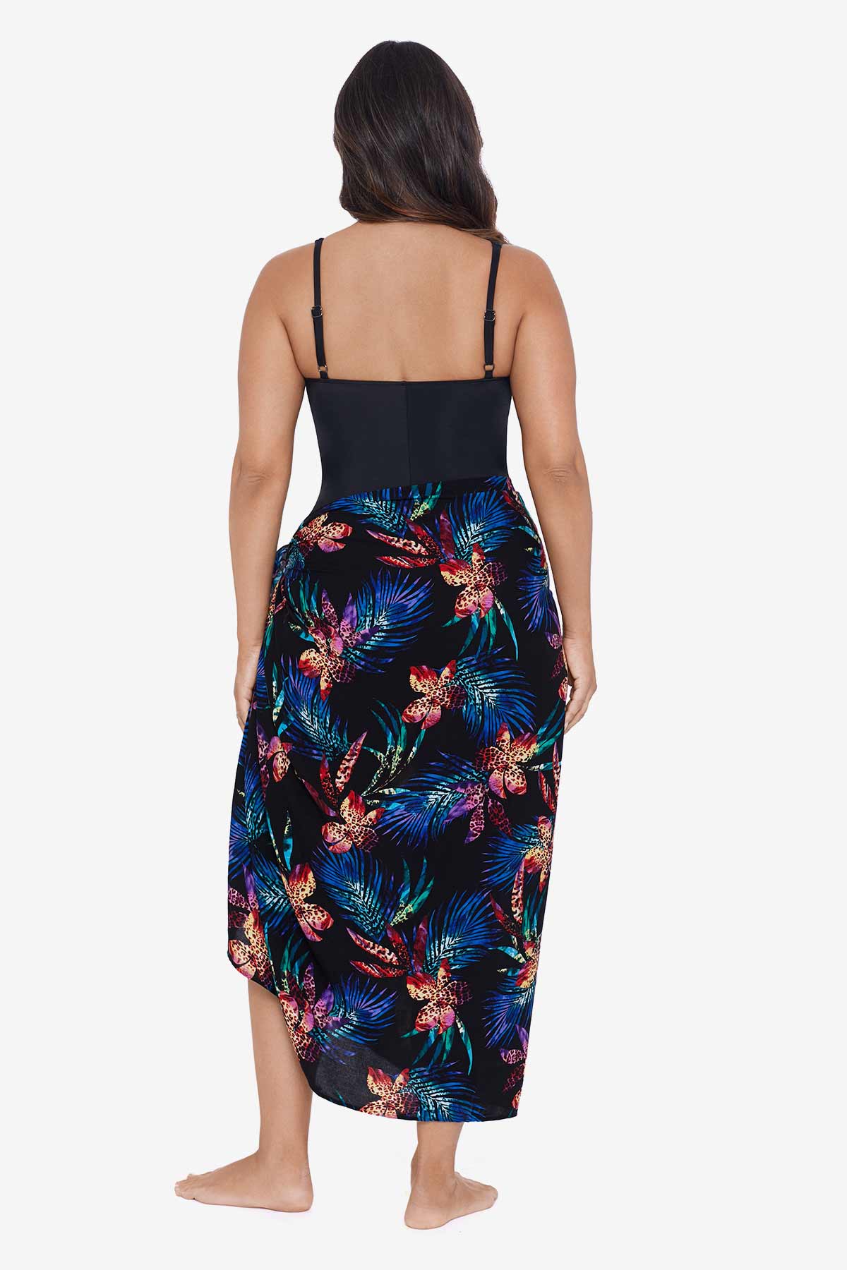 Woman faced away wearing a tropical printed swim wrap cover up with tassels