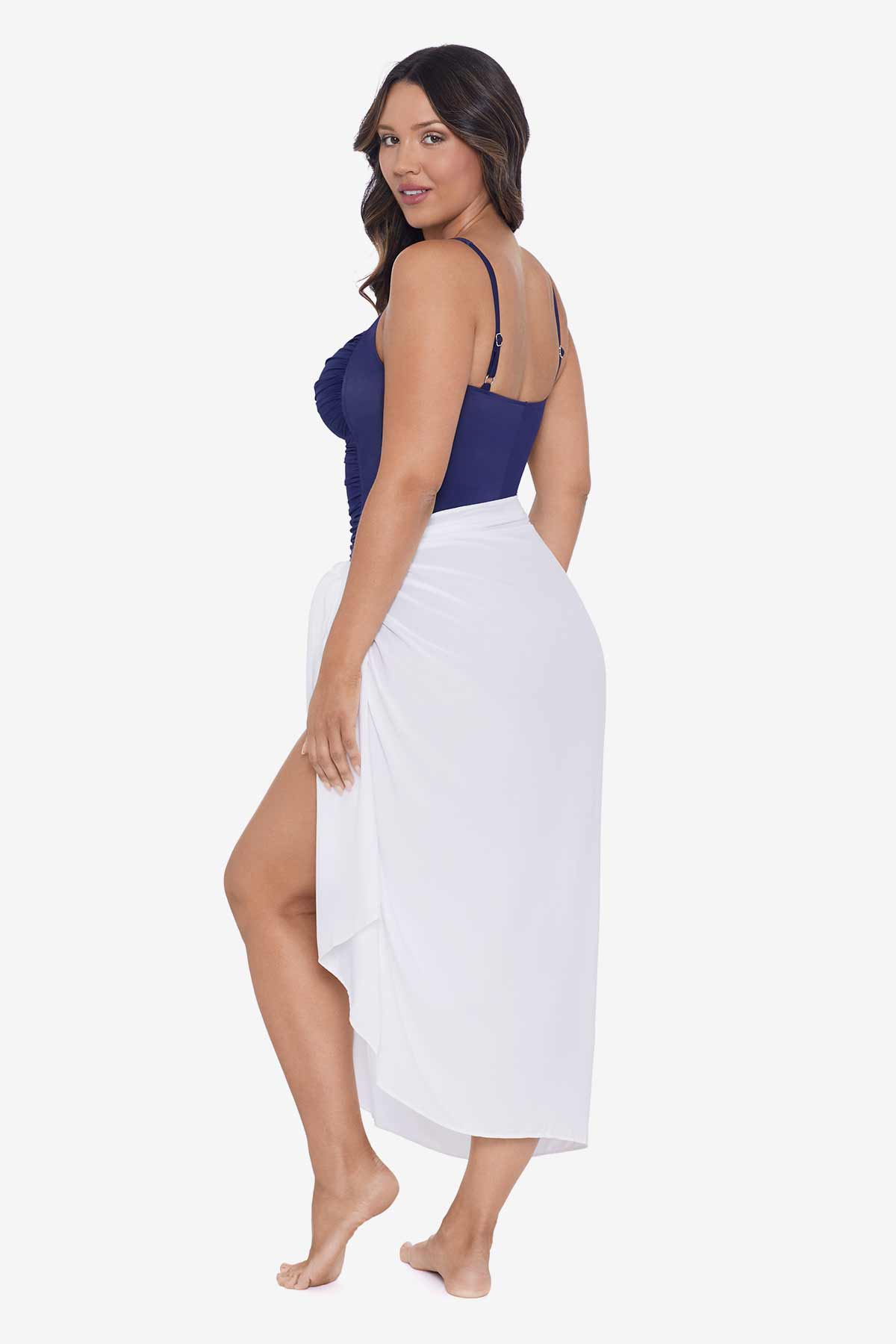 Woman faced left wearing a white swim wrap cover up with tassels