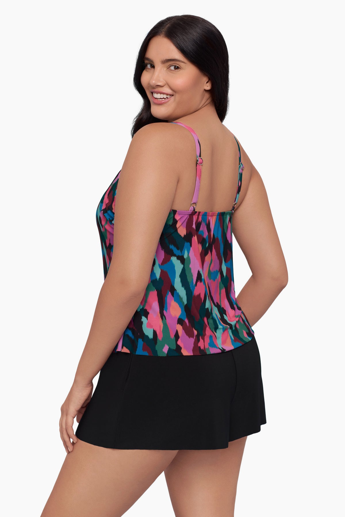 Woman turned left wearing a swim romper with a collage patchwork print