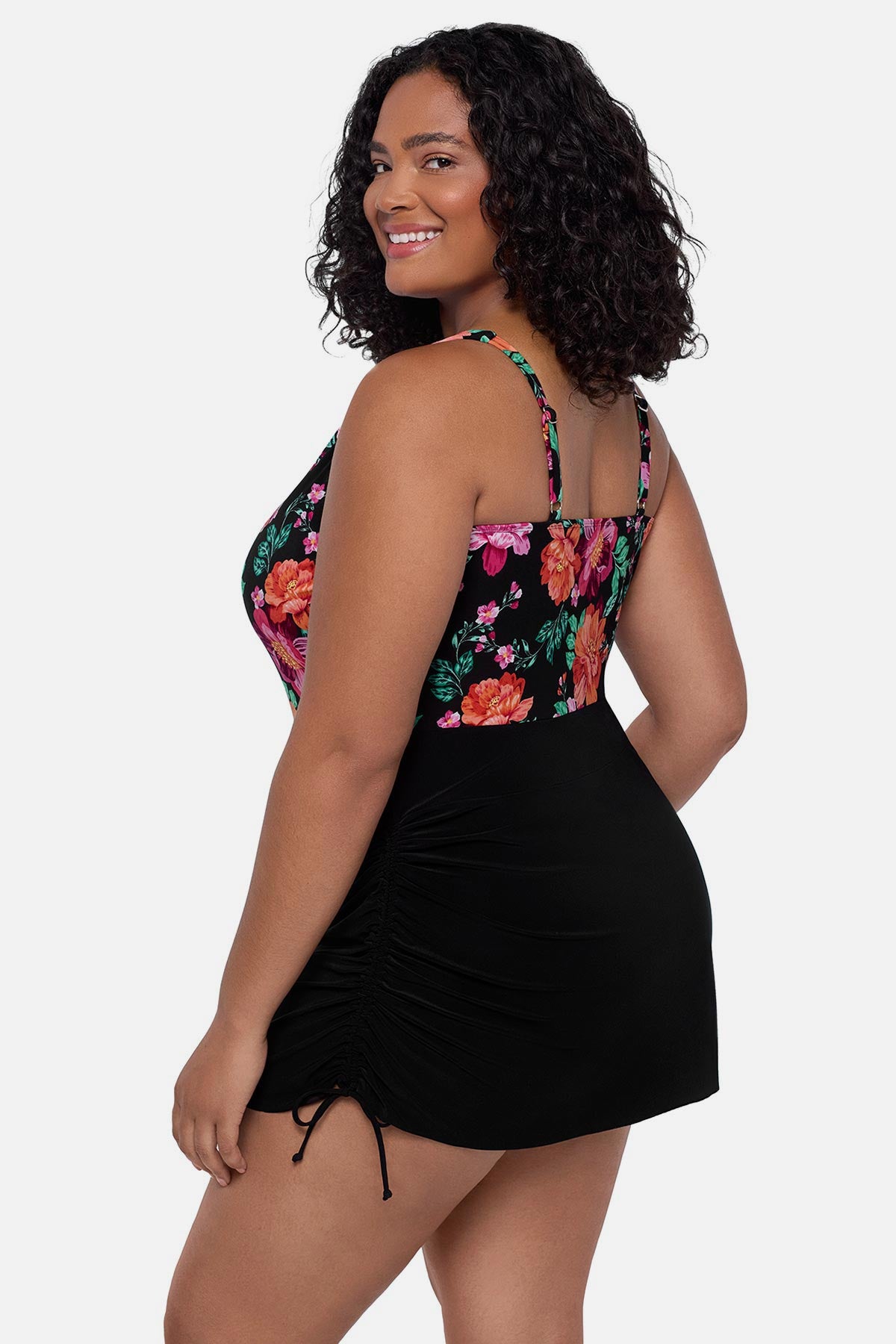 Woman turned left wearing a pink and orange floral printed swim dress