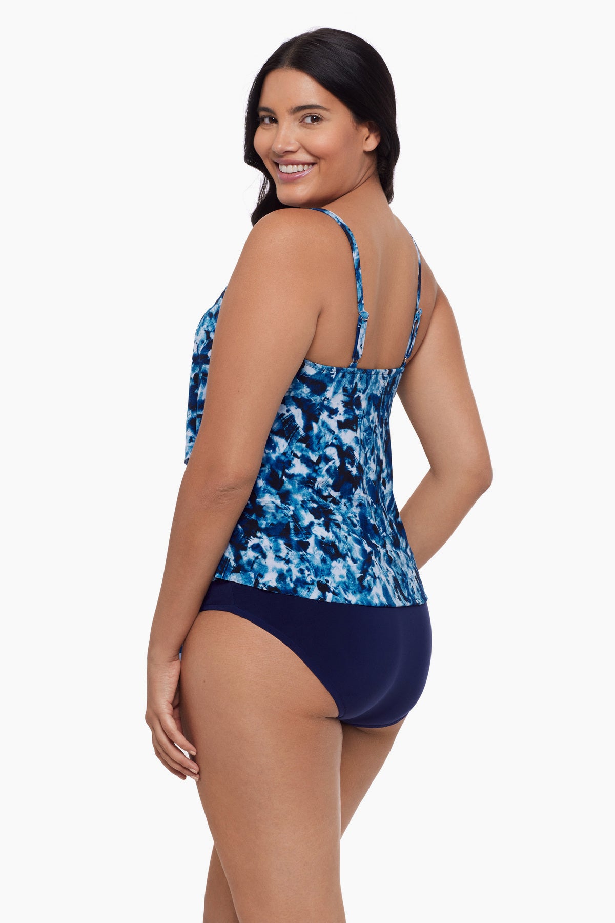 Woman turned left wearing a tiered tankini top with a blue tie dye print