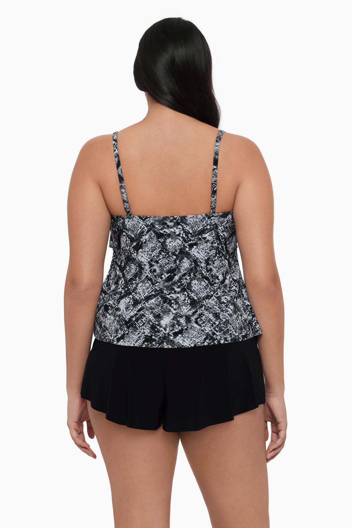 Woman turned away wearing a tiered tankini top with a black and white print