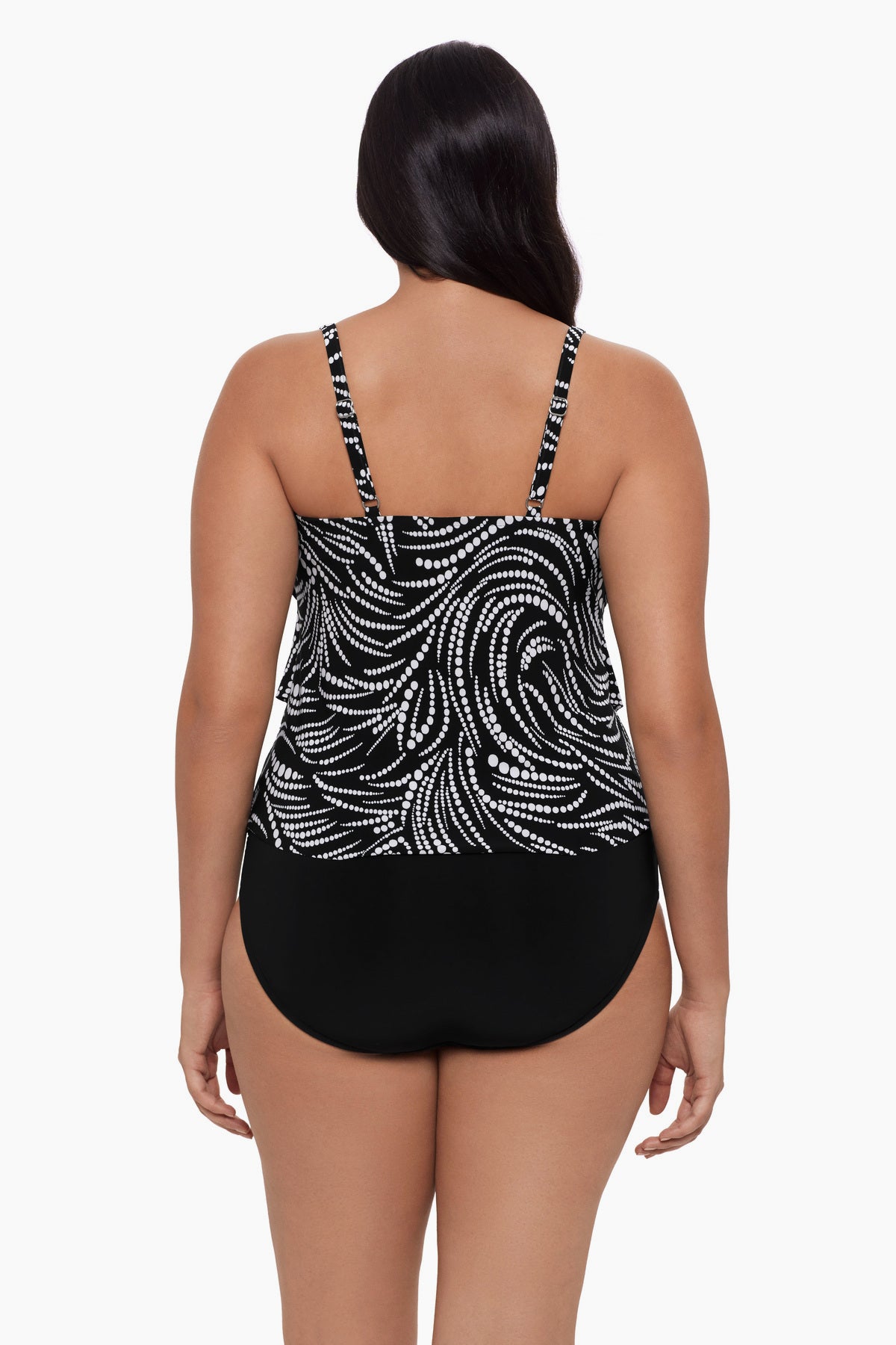 Woman faced away wearing a tankini top with a black and white dot pattern