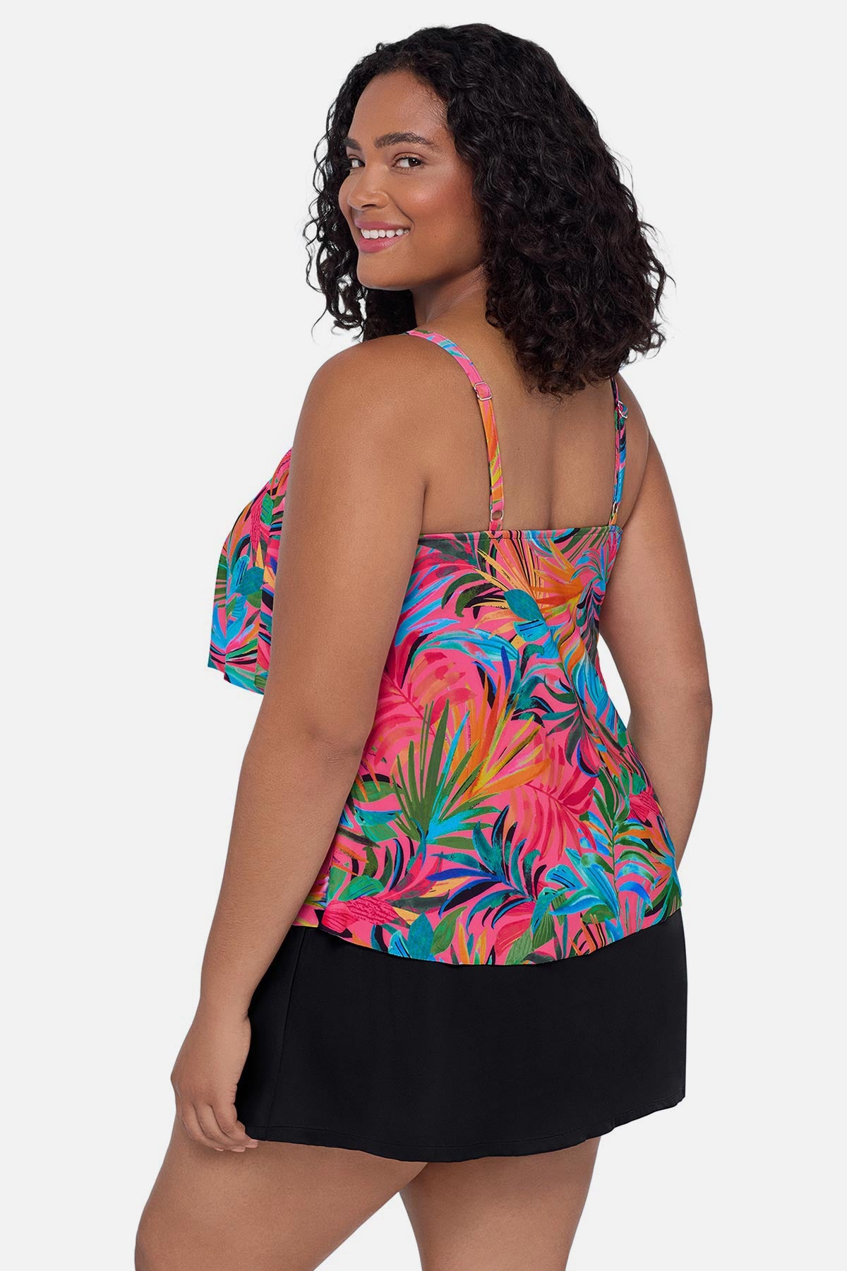 Woman turned left wearing a multicolored palm leaf printed tankini top with ruffles