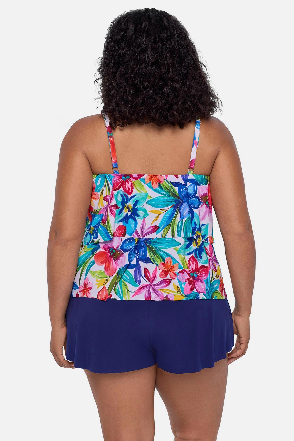 Woman turned away wearing a multicolored floral printed swim romper with ruffles