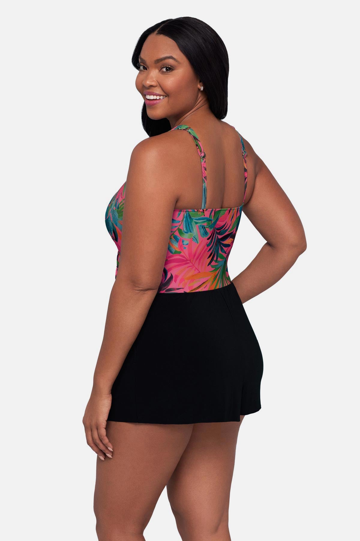 Woman turned left wearing a multicolored palm leaf printed swim romper