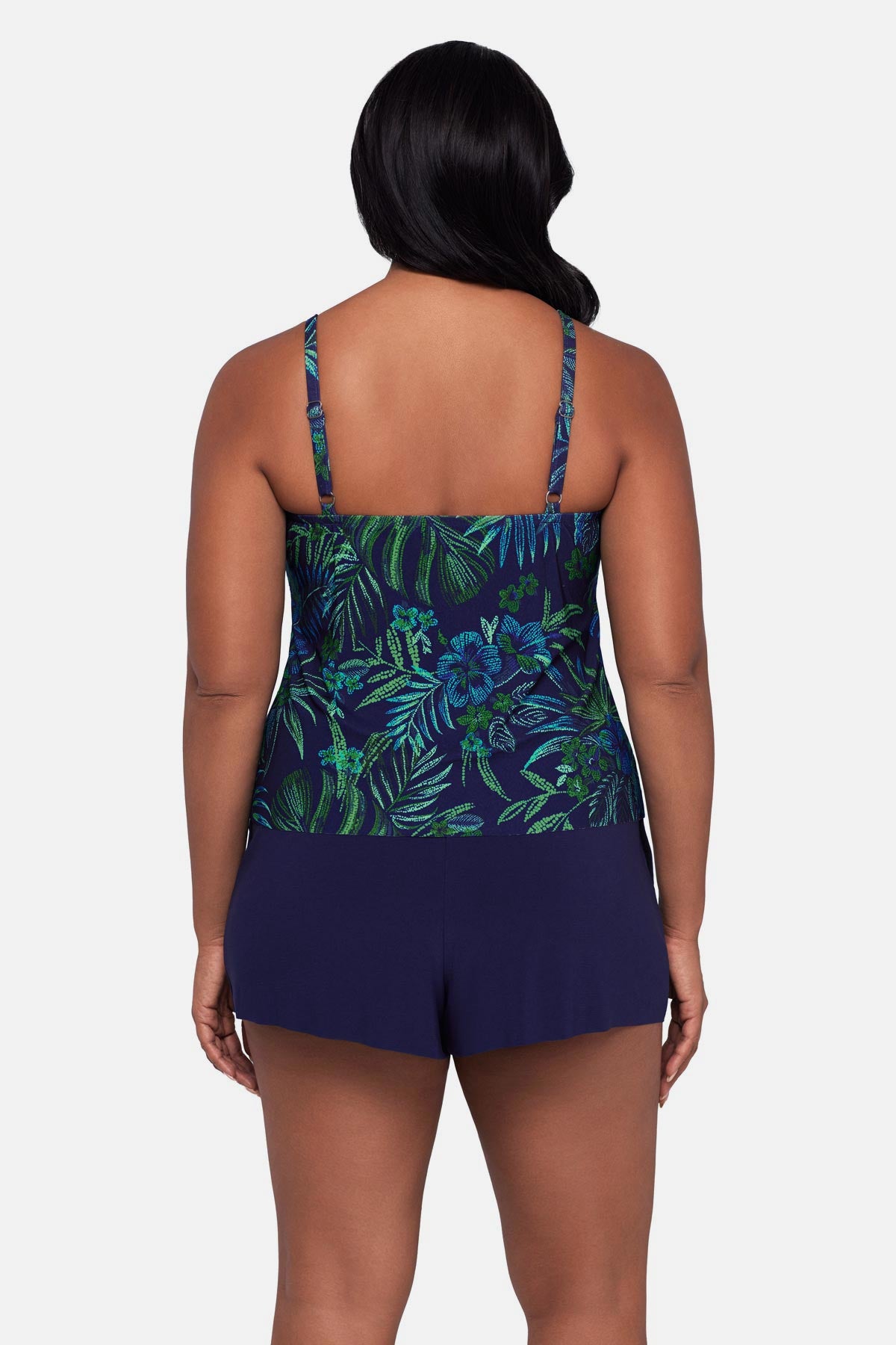 Woman turned away wearing a blue and green jungle printed swim romper