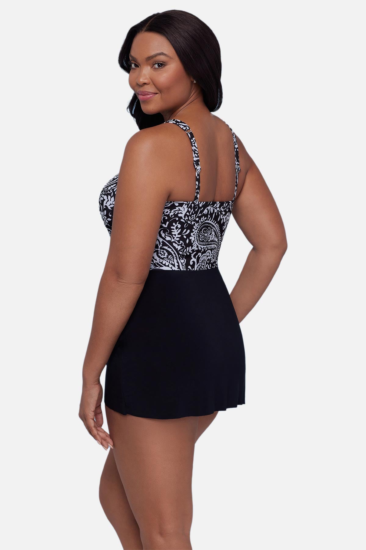 Woman turned left wearing a black and white paisley printed swim dress