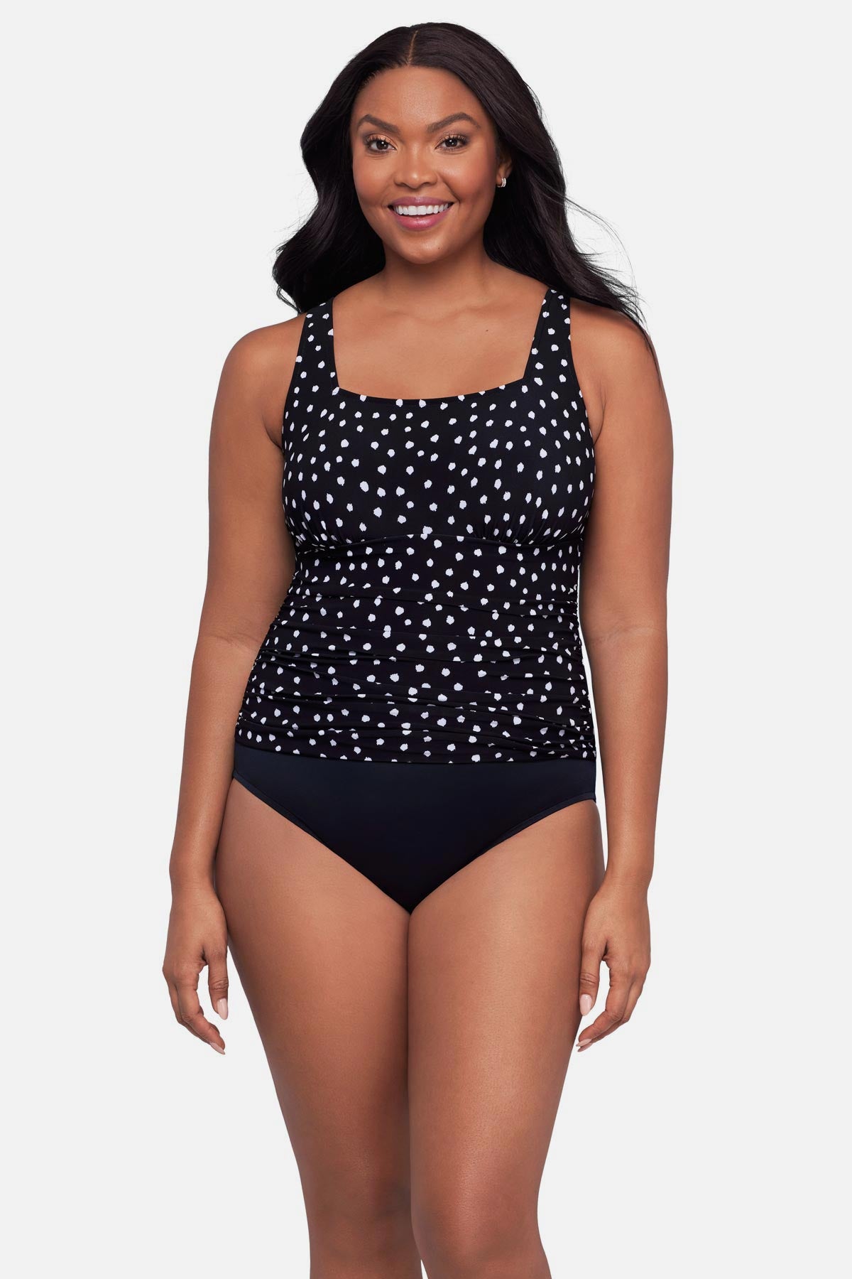 Woman wearing a black and white polka dot one-piece swimsuit
