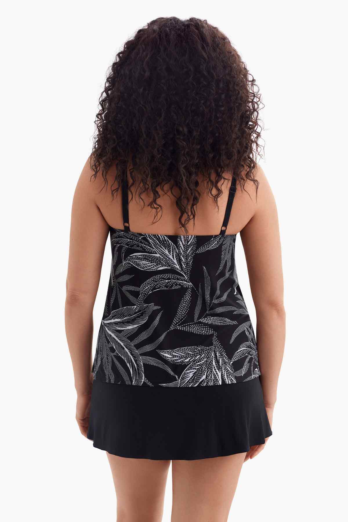 Woman faced away wearing a one-piece swimsuit with a black and white pattern