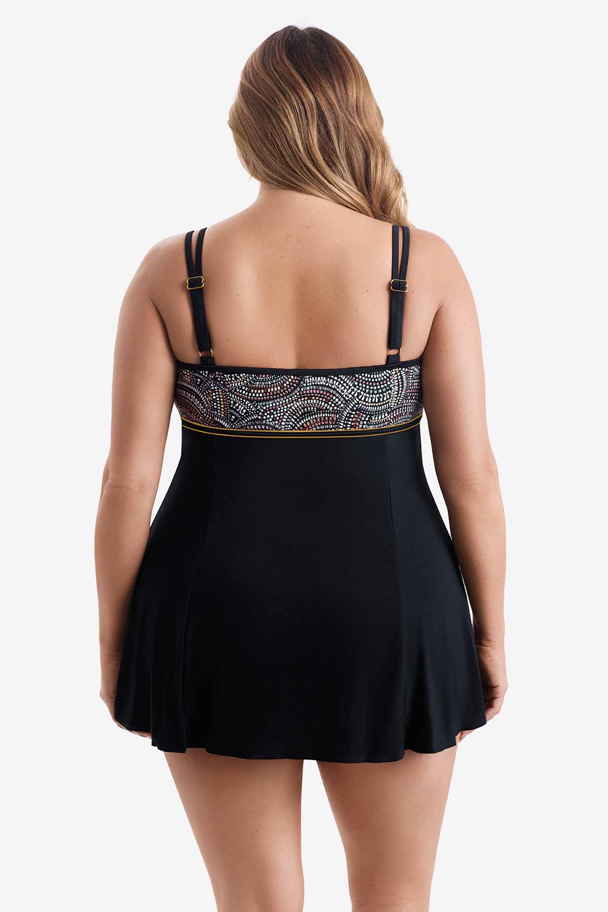 Woman turned away wearing a swim dress with multicolored dots on the bust