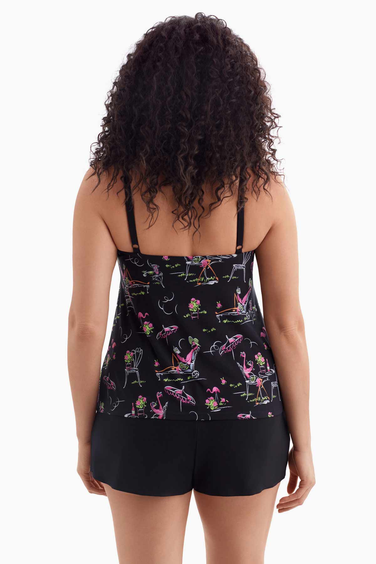 Woman turned away wearing a one-piece tiered swimsuit with a flamingo print