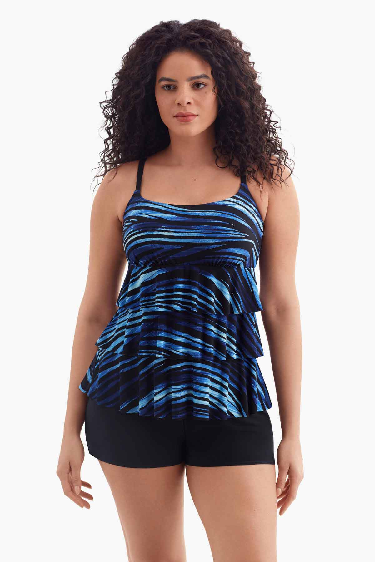 Woman wearing a one-piece tiered swimsuit with a black and blue print