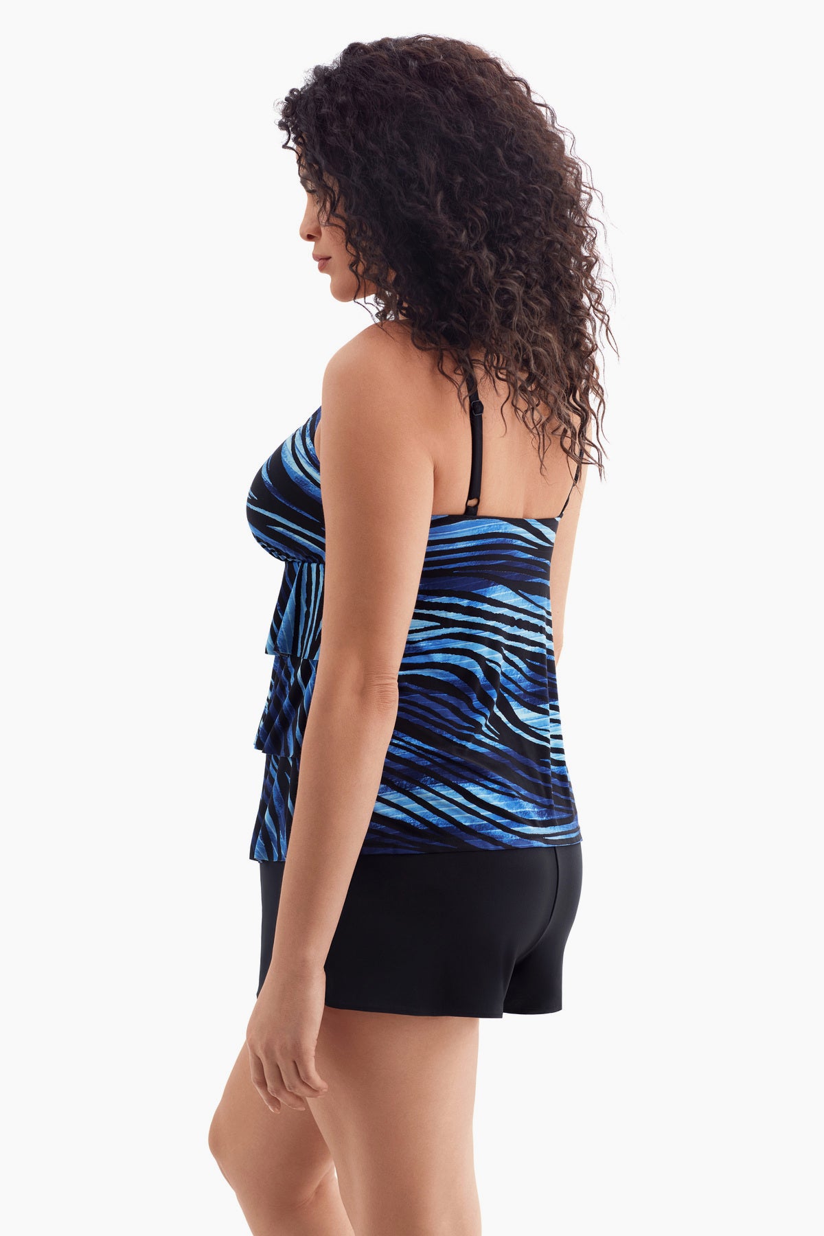 Woman faced left wearing a one-piece tiered swimsuit with a black and blue print