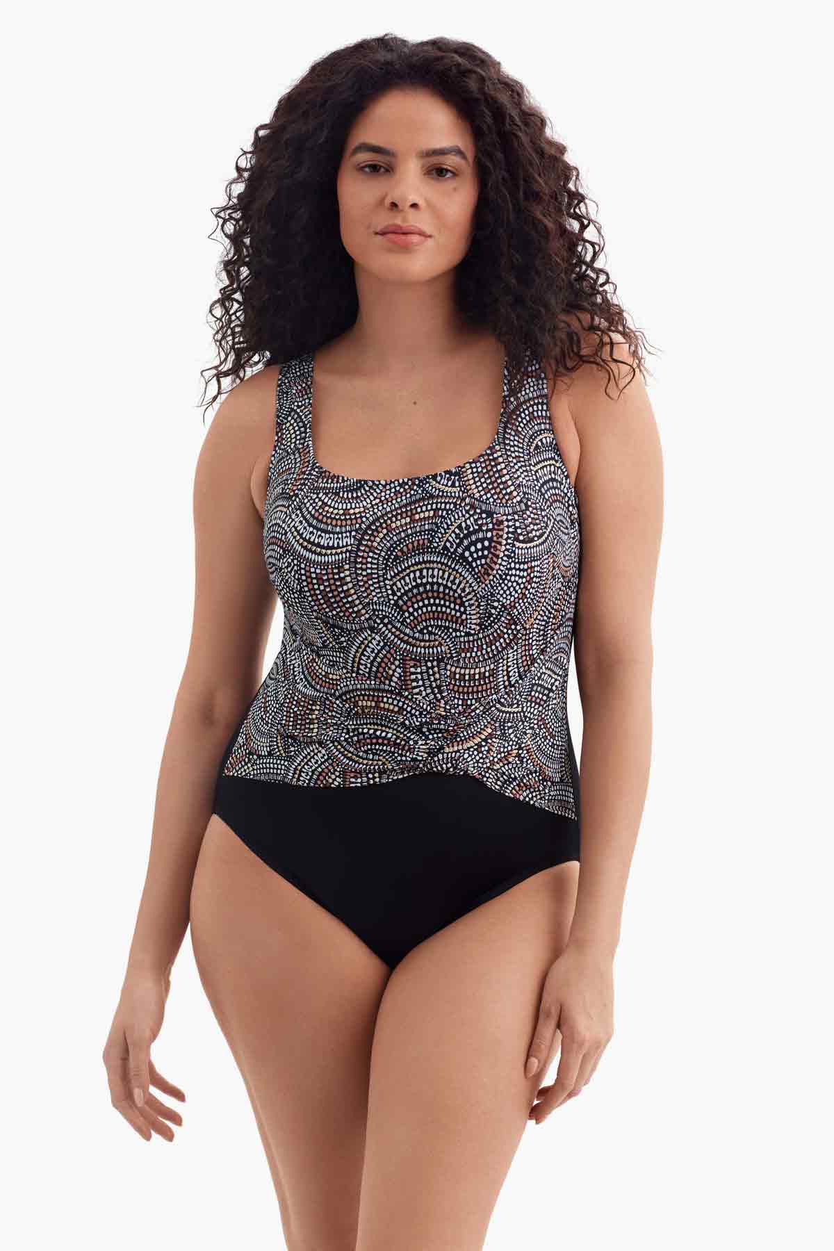 Woman wearing a one-piece swimsuit with a multicolored dot pattern