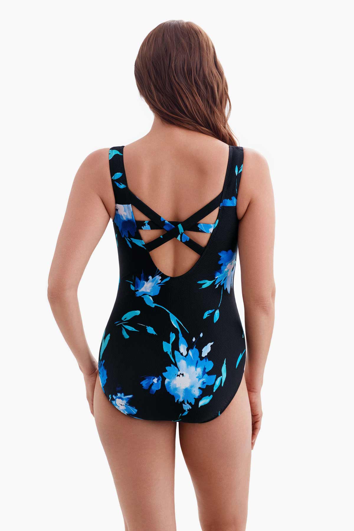 Woman turned away wearing a one-piece swimsuit with a blue floral pattern and X back