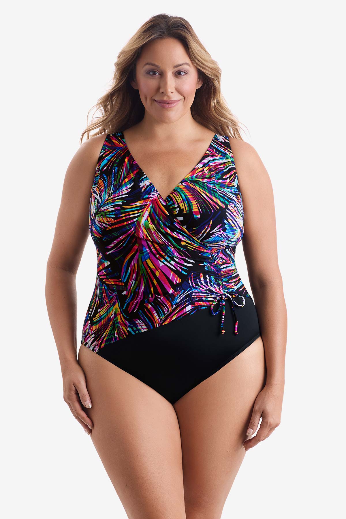 Woman wearing a rainbow abstract printed one-piece swimsuit with a side tie
