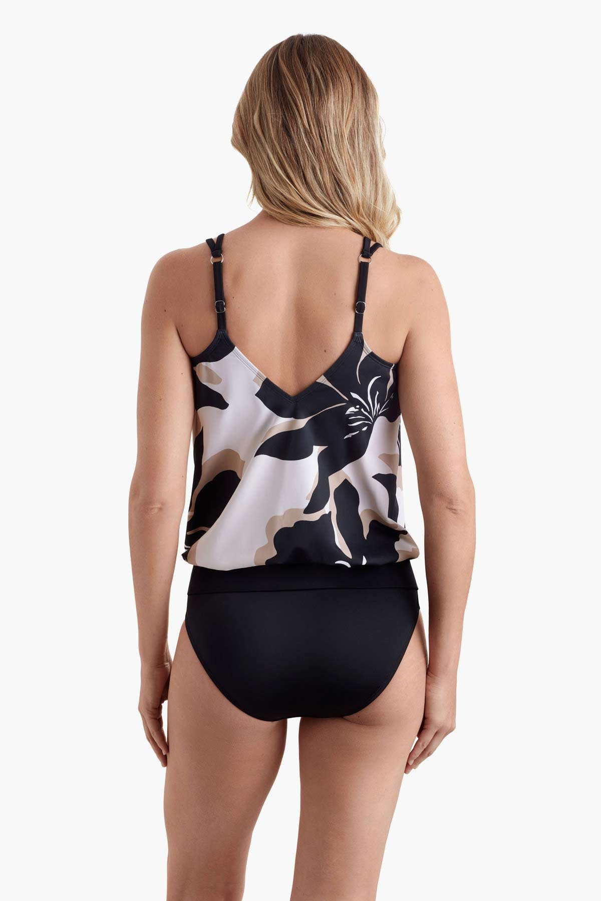 Woman faced away wearing a tankini top with a large black and white flower print