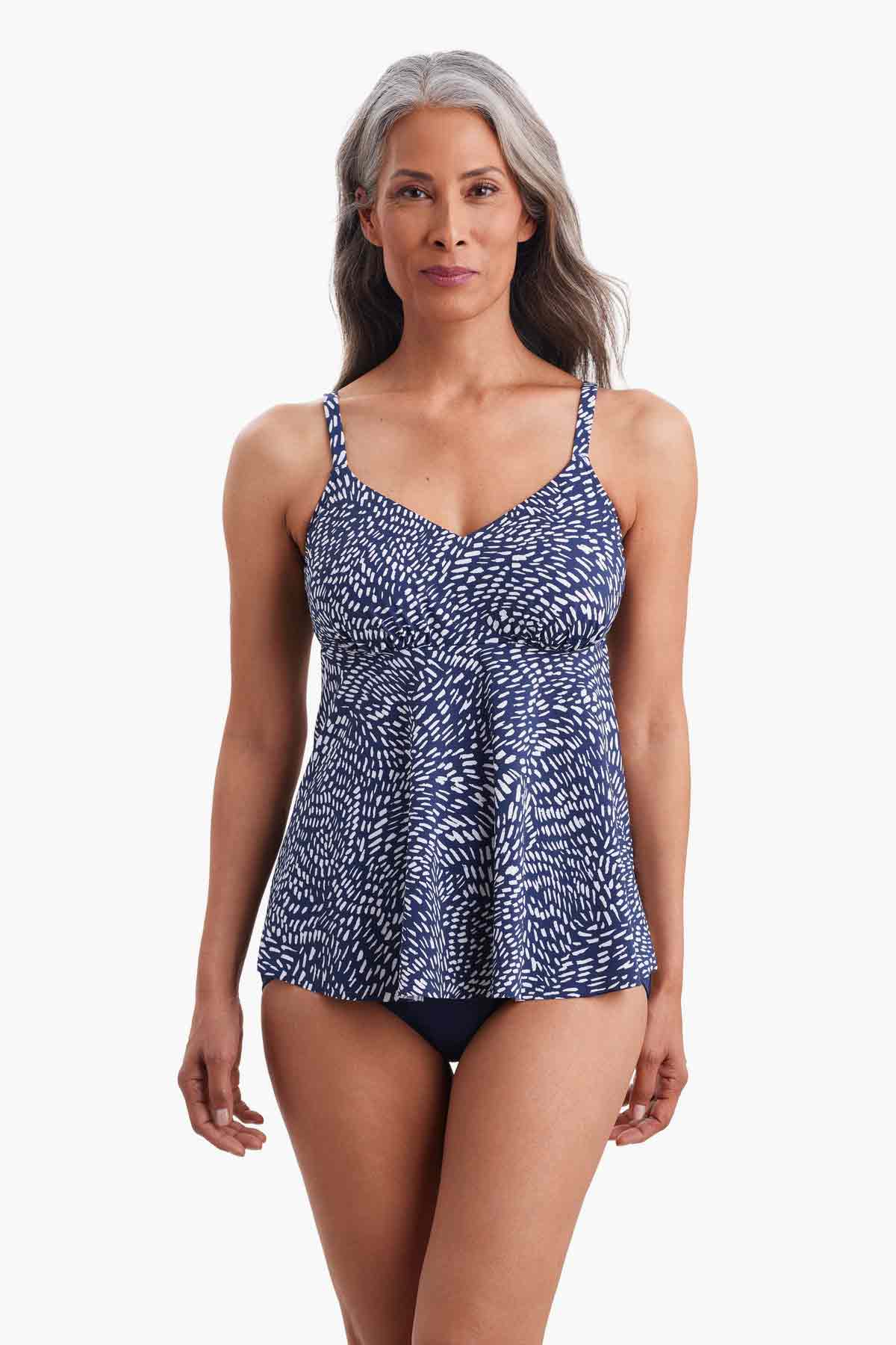 Woman wearing a tankini top with a navy and white print