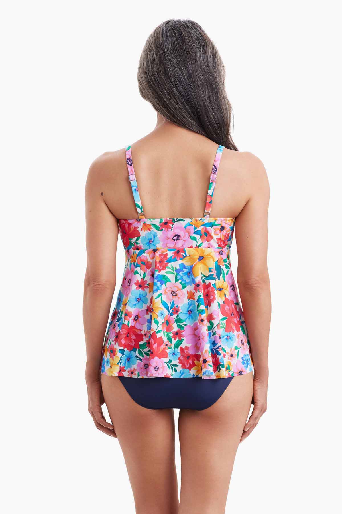 Woman turned away wearing a tankini top with a multicolored floral pattern