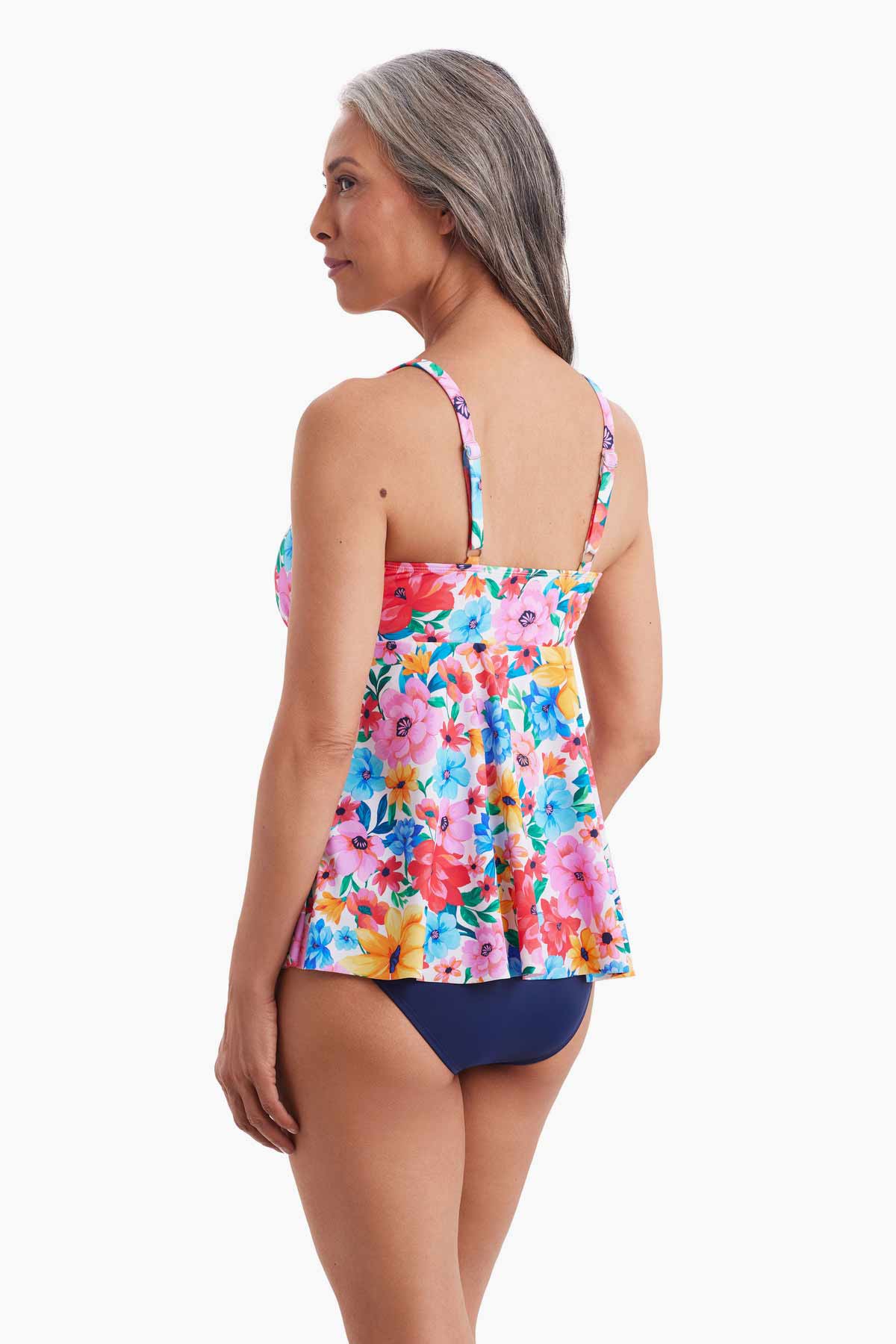 Woman turned left wearing a tankini top with a multicolored floral pattern