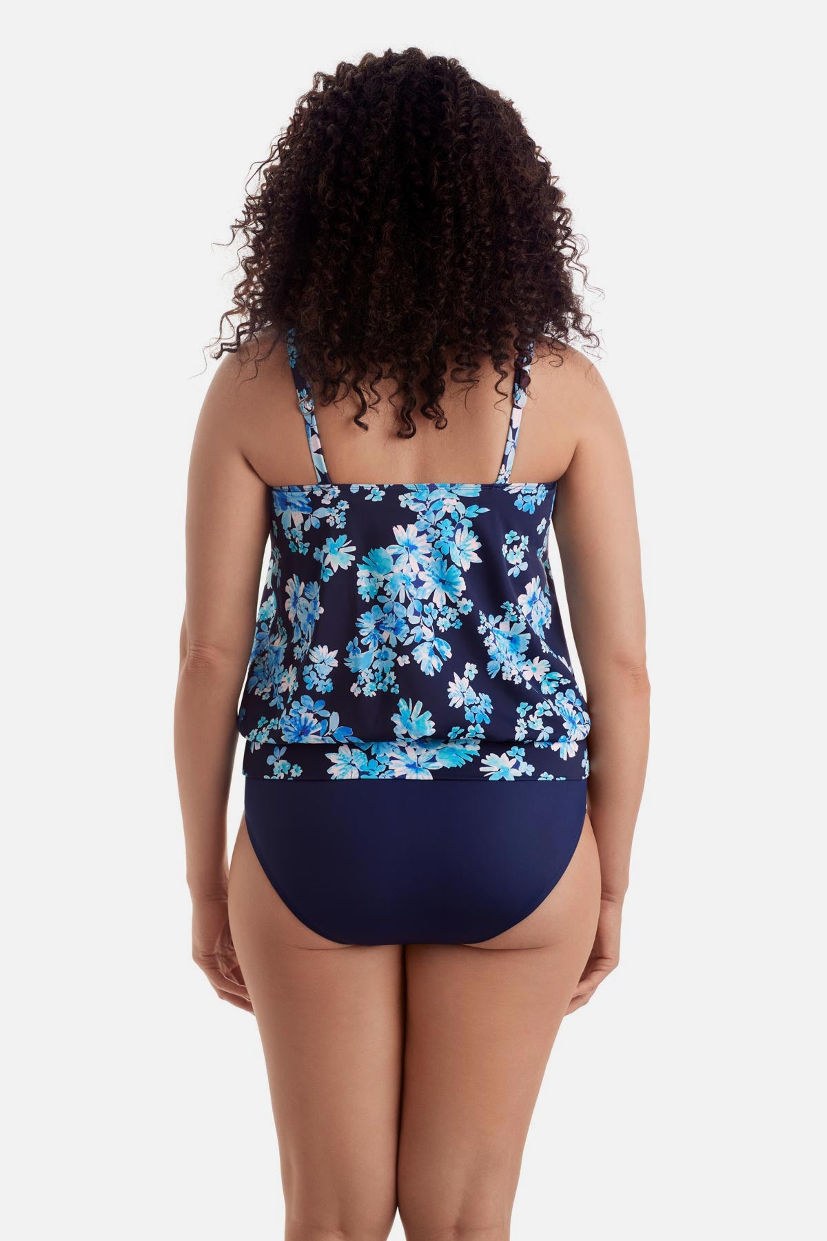 Woman turned away wearing a blue floral print shirred neck blouson tankini top