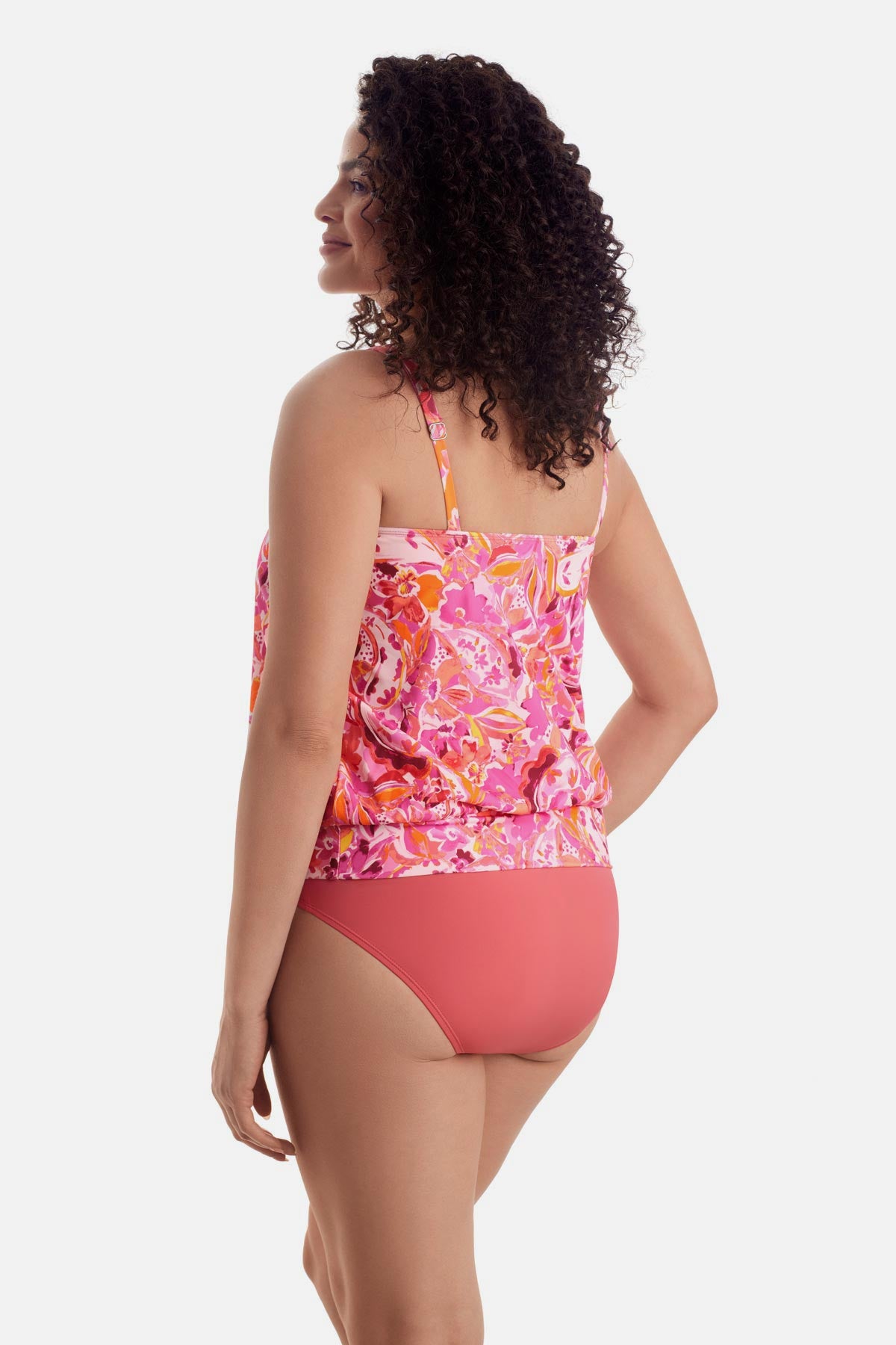Woman turned left wearing a pink floral printed shirred neck blouson tankini top