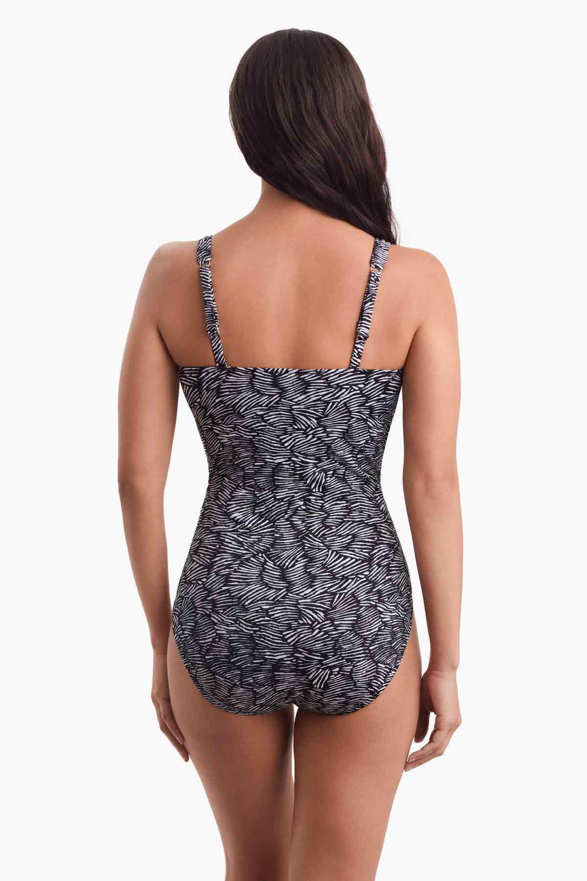 Woman turned away wearing a black and white one-piece swimsuit