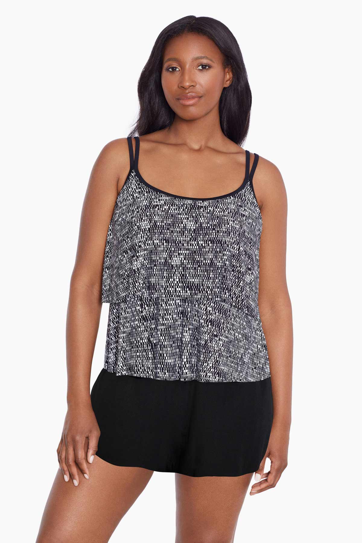 Woman wearing a black and white static pattern ruffle skirtini swimsuit