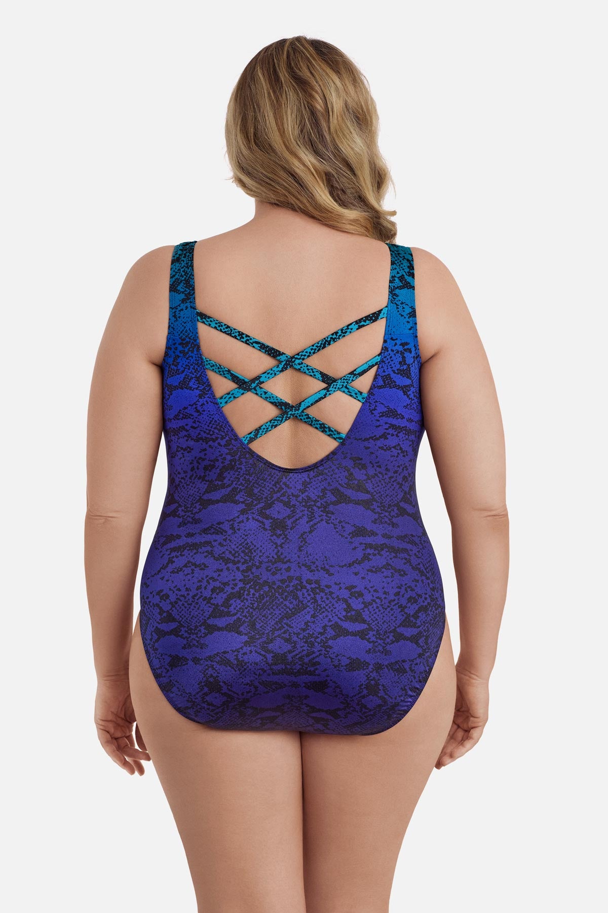 Woman turned away wearing a blue ombre animal-esque printed one-piece swimsuit with an X back