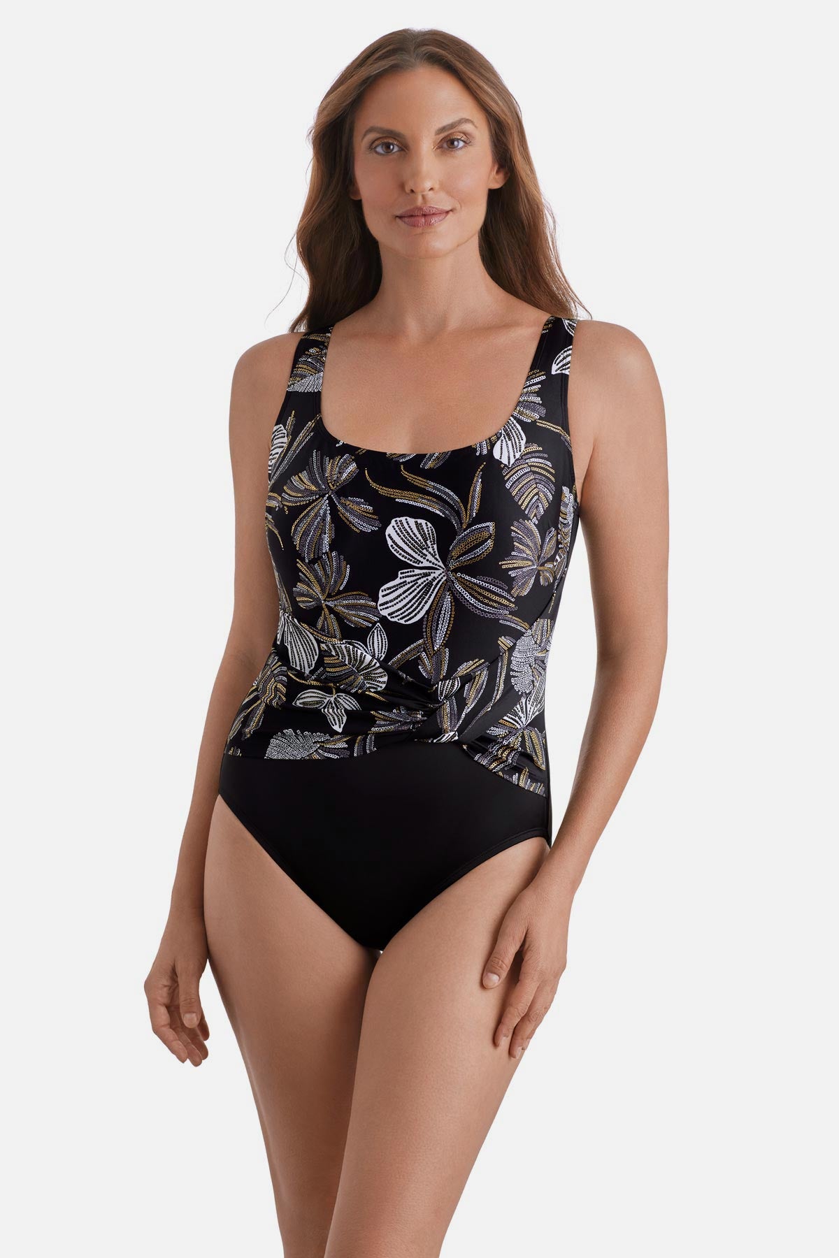 Woman wearing a gold and white floral pattern one-piece swimsuit with a pull sash