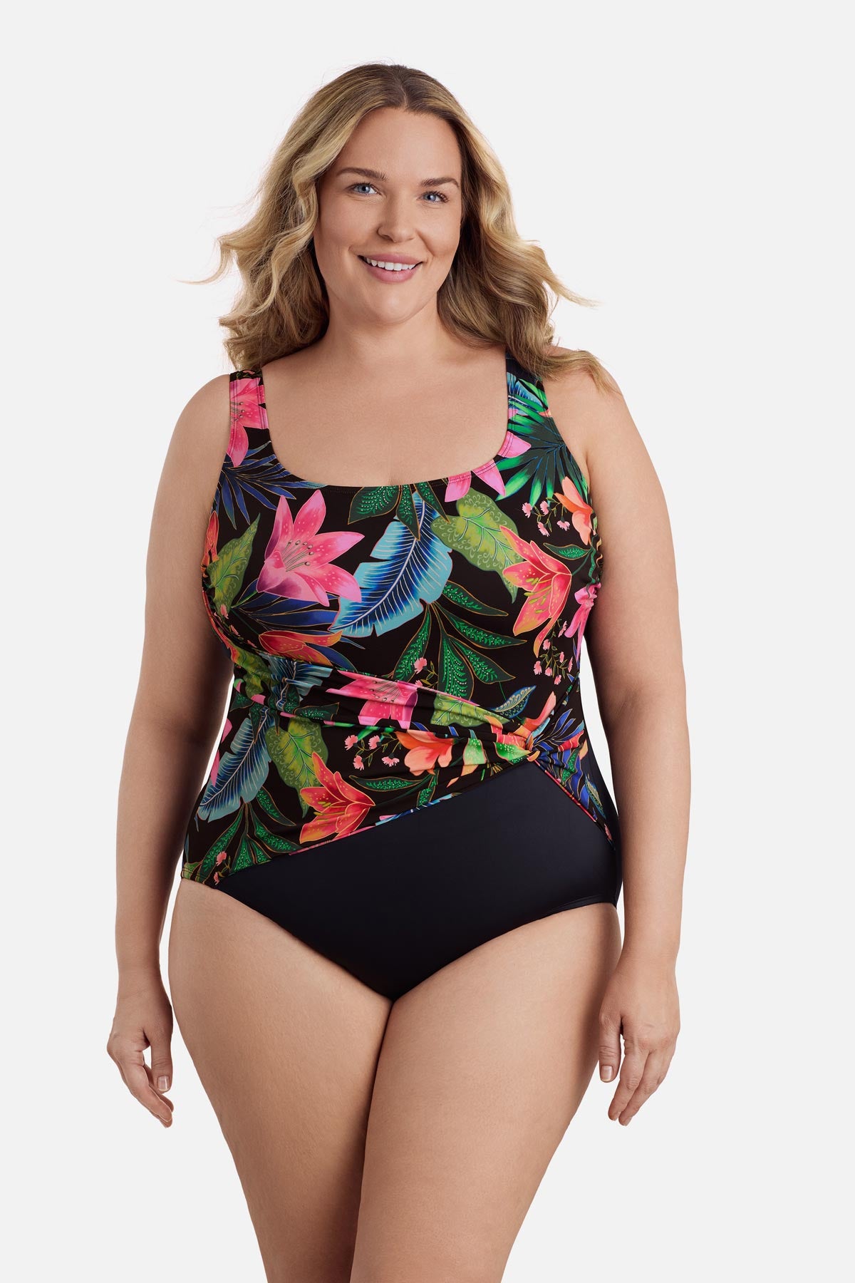 Woman wearing a multicolored floral and palm leaf printed one-piece swimsuit