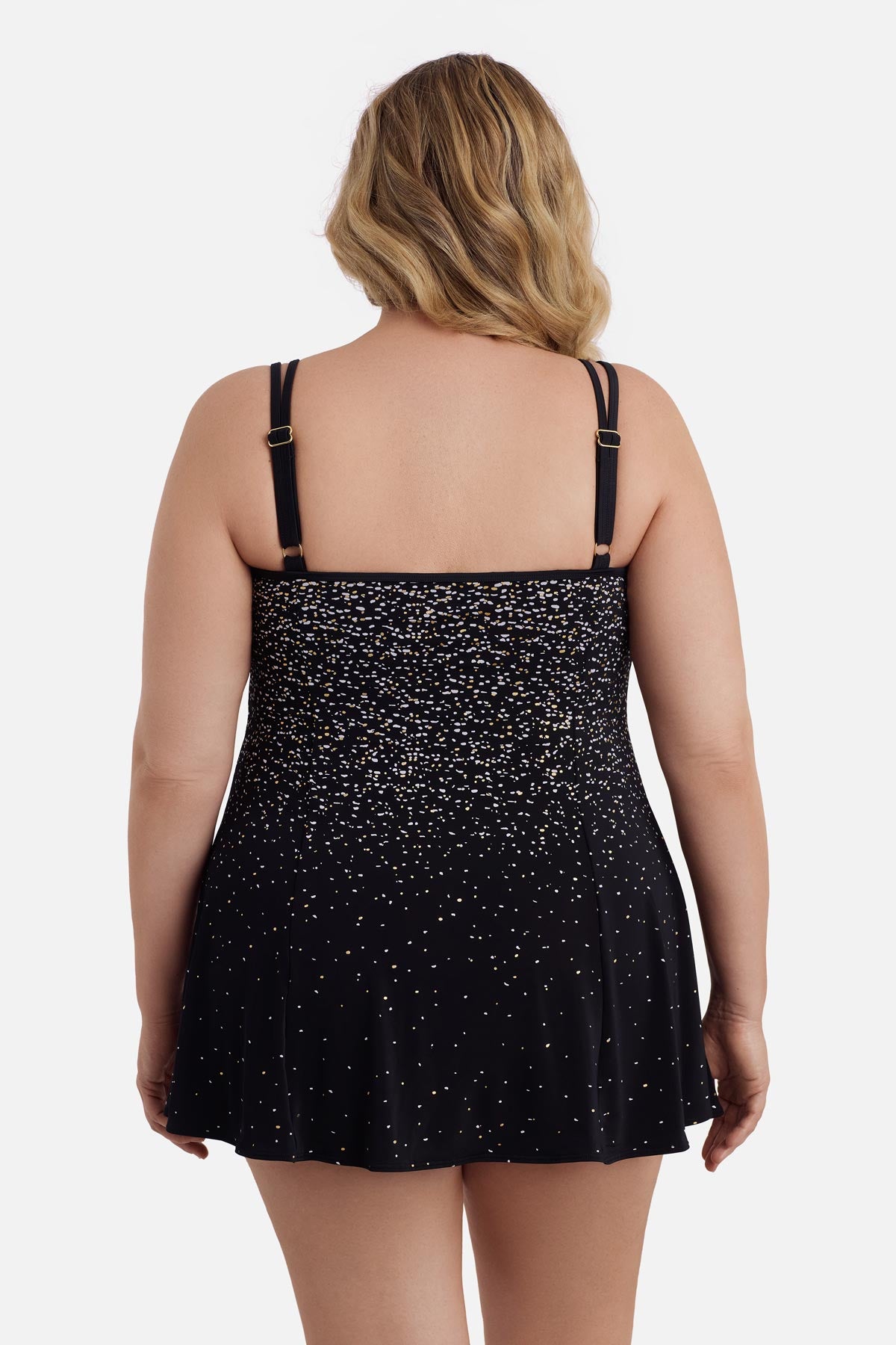 Woman faced away wearing a black and white dot print swim dress