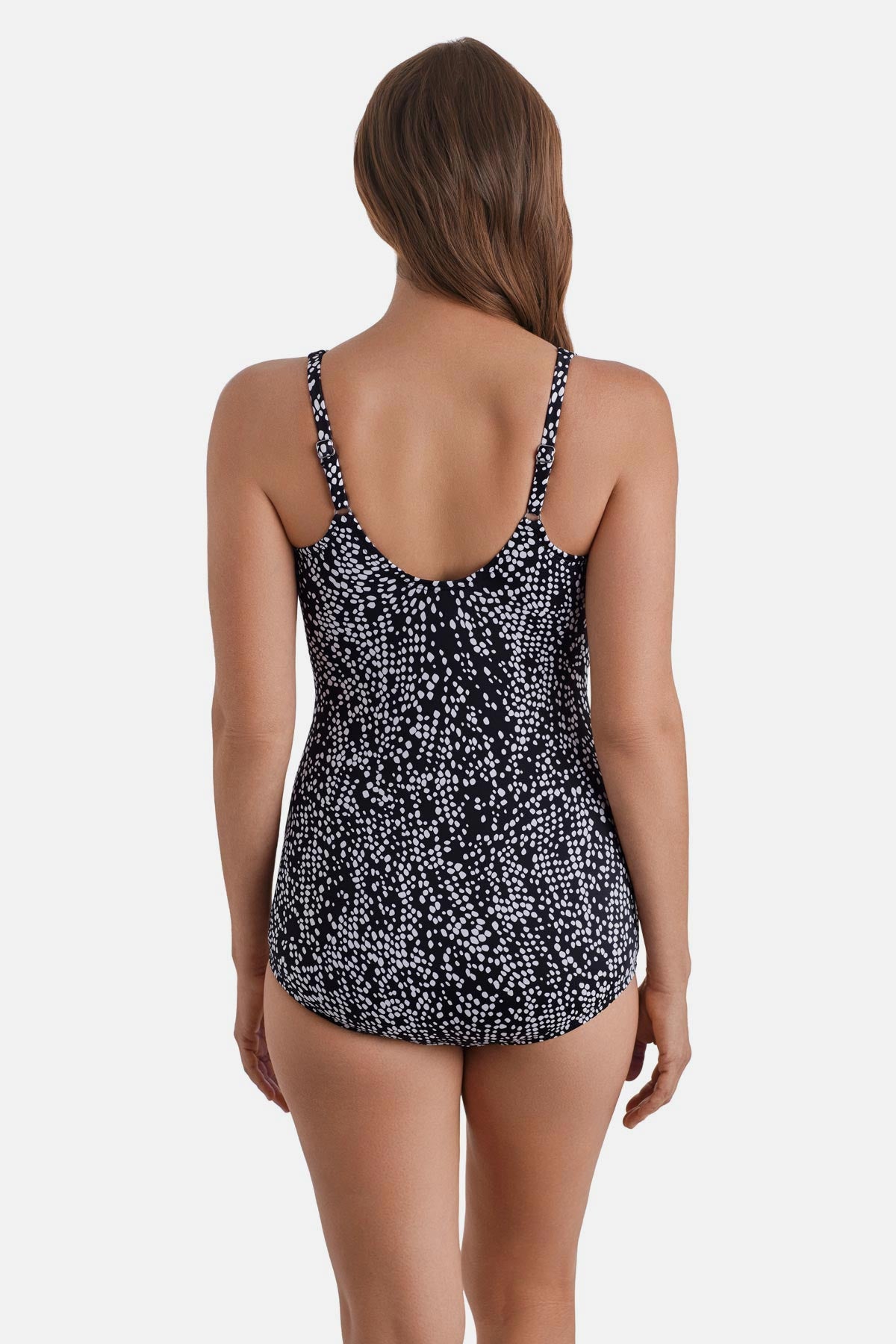Woman turned away wearing a black and white dot printed one-piece swimsuit