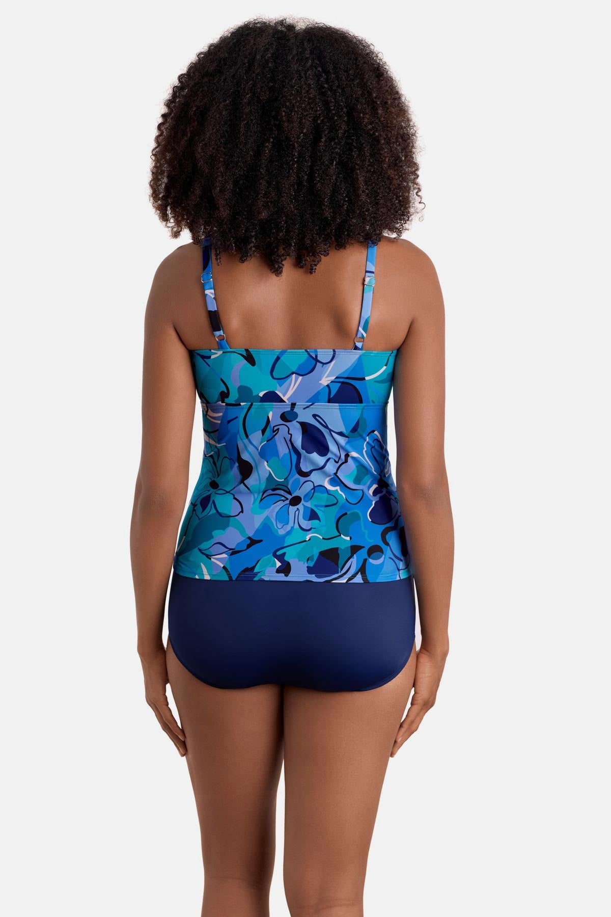 Woman turned away wearing a blue floral printed shirred tankini top