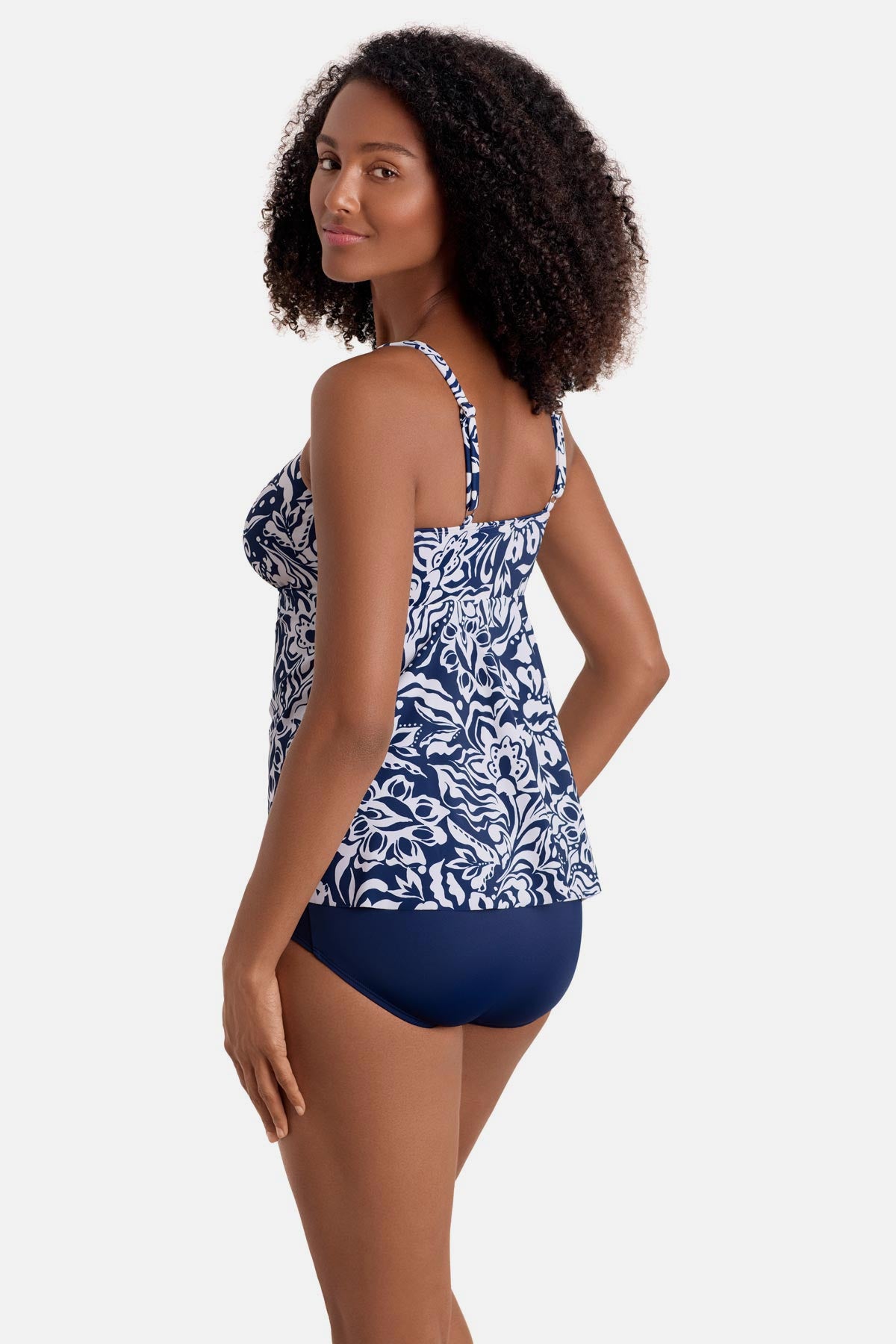 Woman turned left wearing a blue and white abstract floral printed tankini top