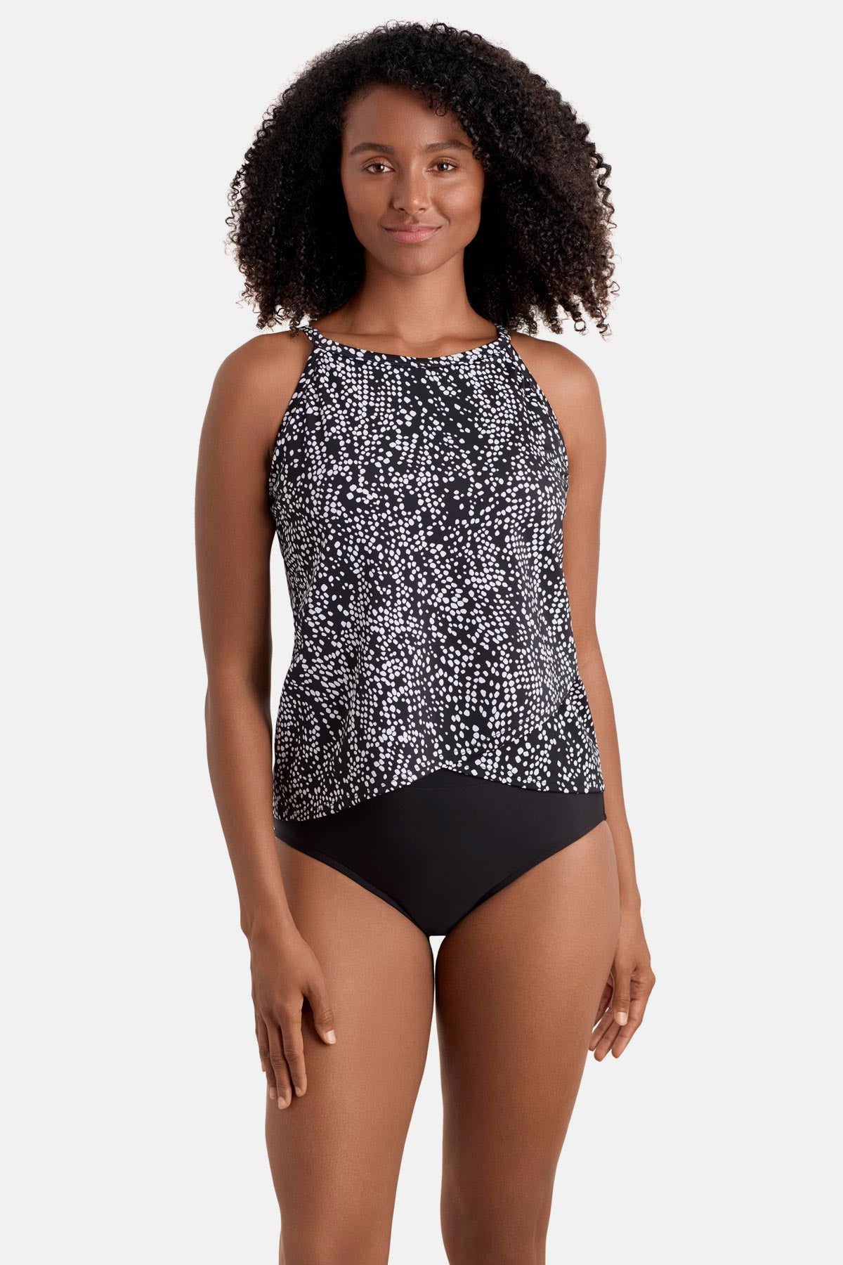 Woman wearing a black and white dot printed high neck tankini top