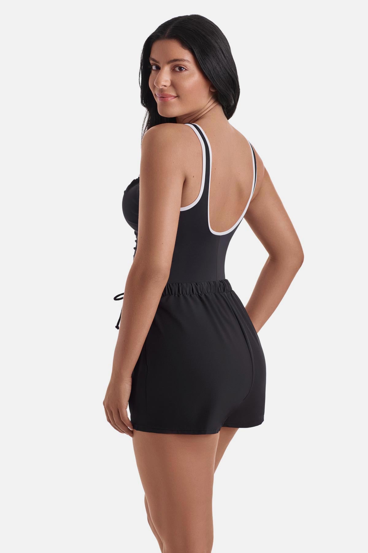 Woman turned left wearing a black and white one-piece swim romper