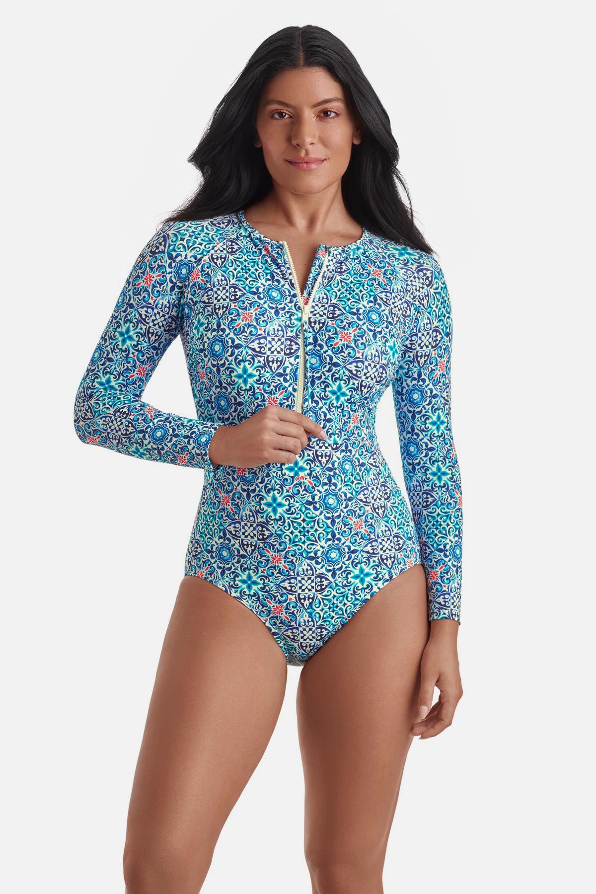 Woman wearing a long sleeve one-piece swimsuit with a blue tile print