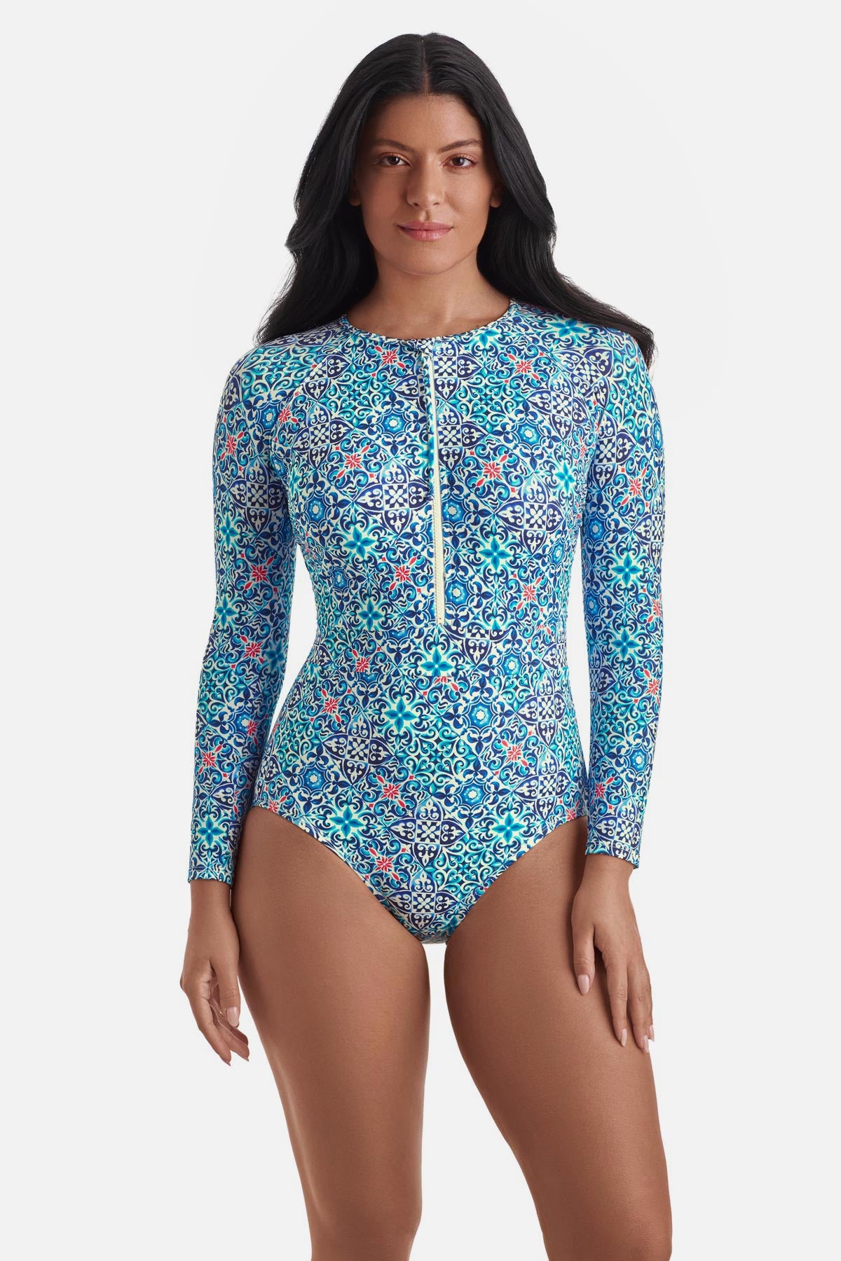 Woman wearing a long sleeve one-piece swimsuit with a blue tile print