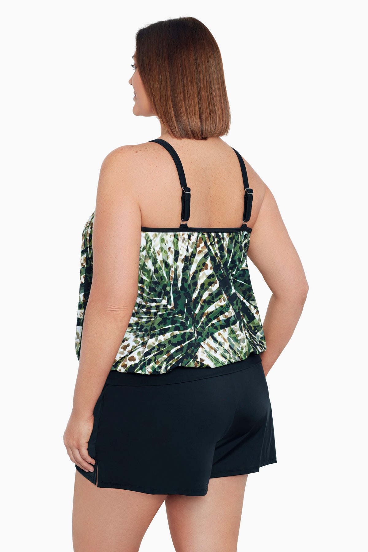 Woman turned left wearing a green and white palm leaf blouson tankini top
