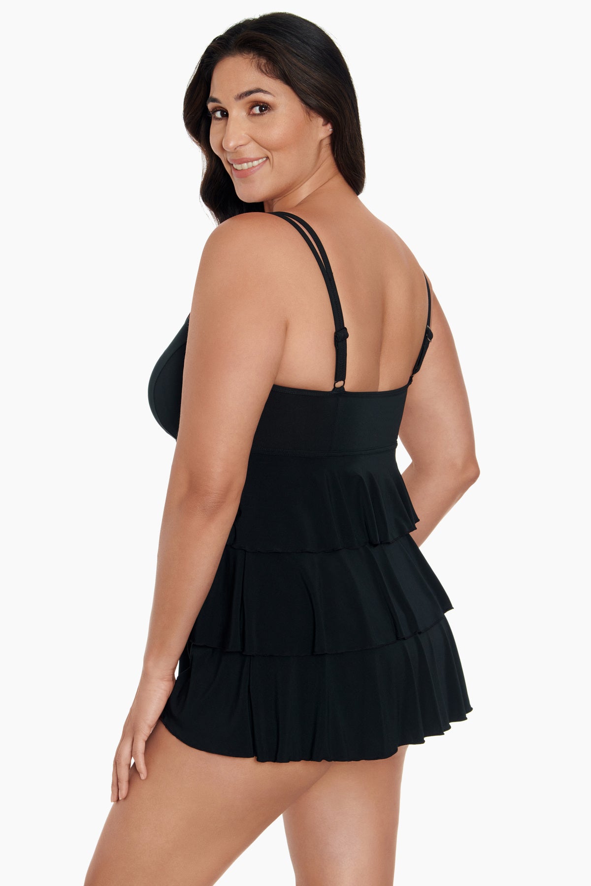Woman turned left wearing a black swim dress with ruffled tiers
