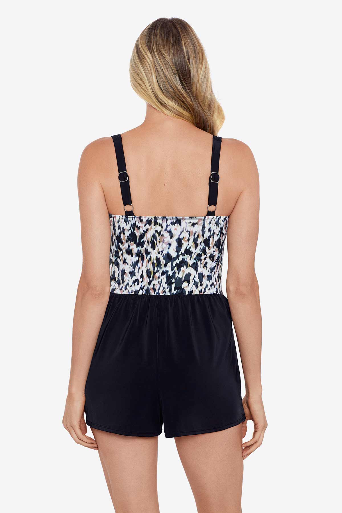 Woman faced away wearing a leopard printed swim skort romper