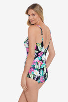 Woman turned left wearing a multicolored tropical printed one-piece swimsuit