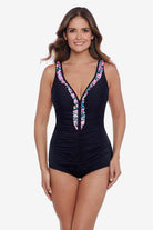 Woman wearing a black one-piece swimsuit with ruffled piping down the front