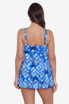 Woman faced away wearing a blue and white abstract pattern triple tiered ruffle swim dress