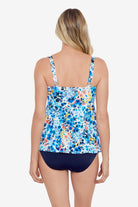 Woman faced away wearing a multicolored small floral printed tiered ruffle tankini top