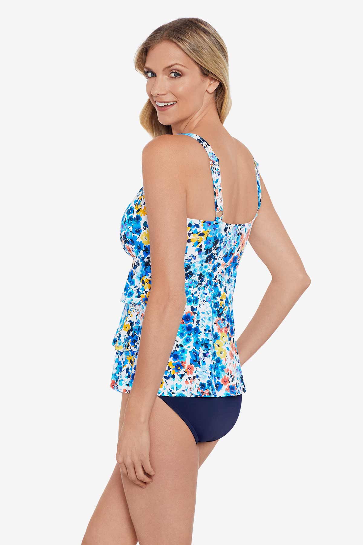 Woman turned left wearing a multicolored small floral printed tiered ruffle tankini top