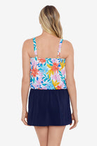 Woman faced away wearing a multicolored tropical print blouson swim dress