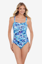 Woman wearing a blue and white feather/leaf pattern one-piece swimsuit